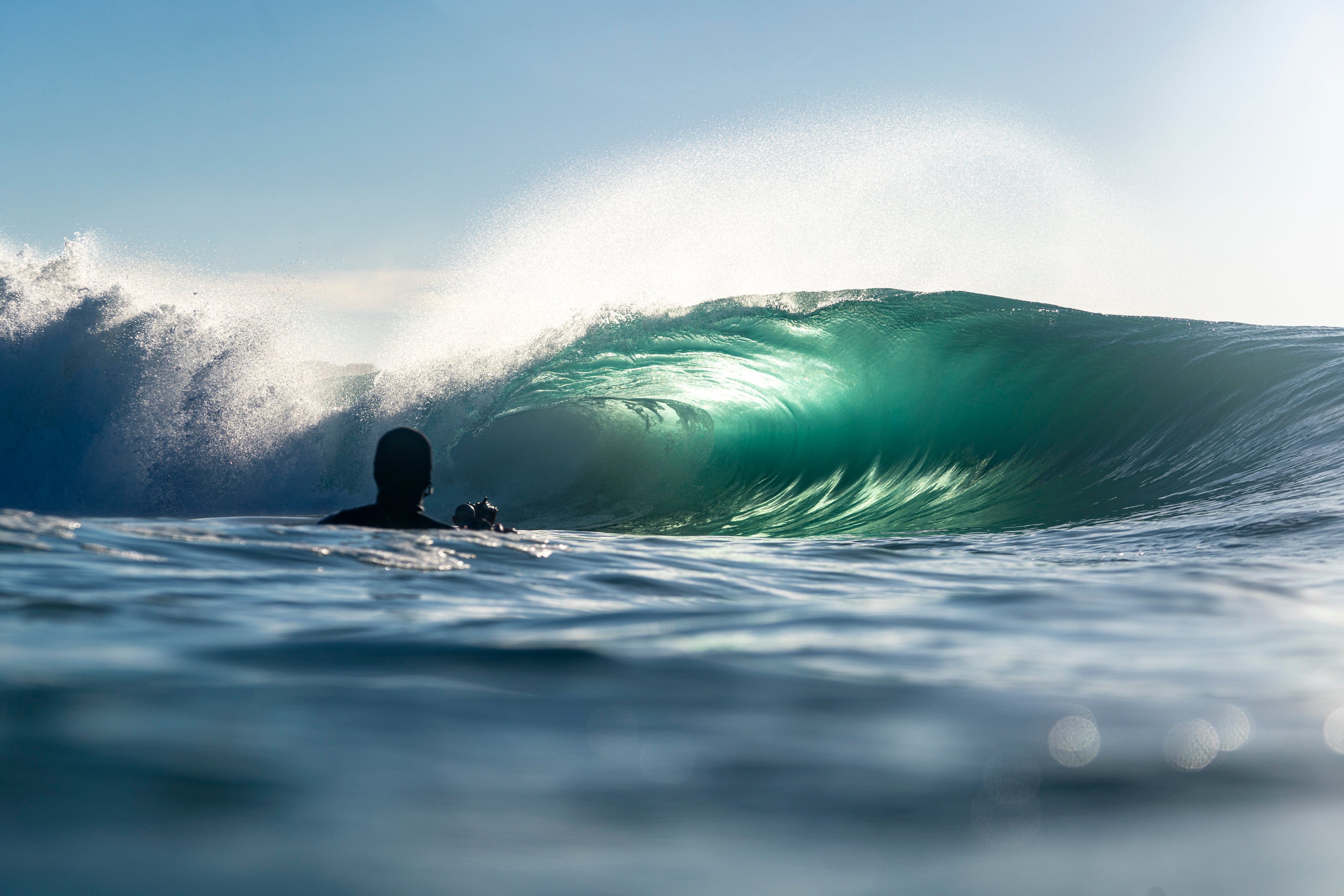 Surfer watching a large wave with a clear sky. The Wedge. Newport Beach, California.