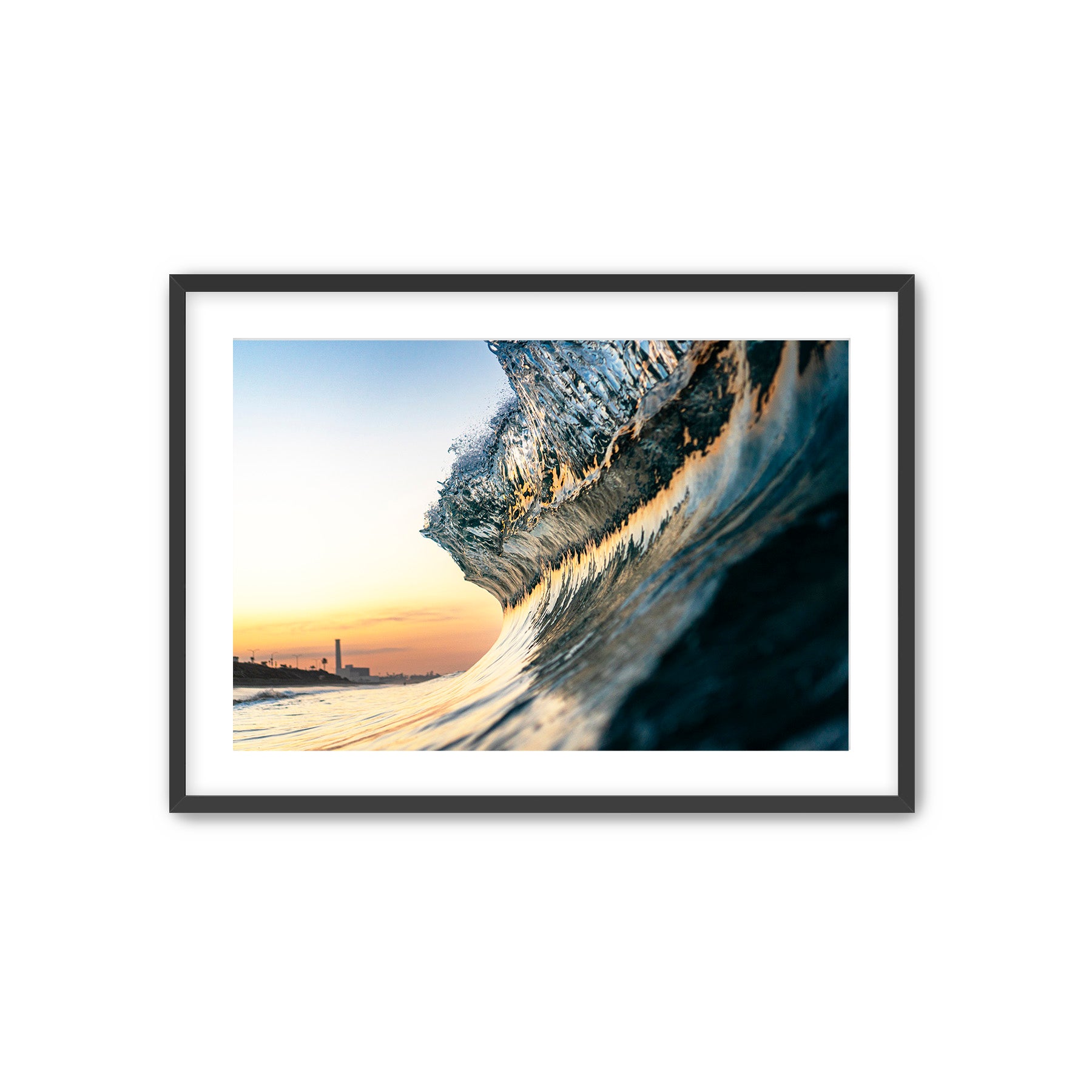 Framed photograph of a sunrise lit wave with the Carlsbad power plant in the background. 