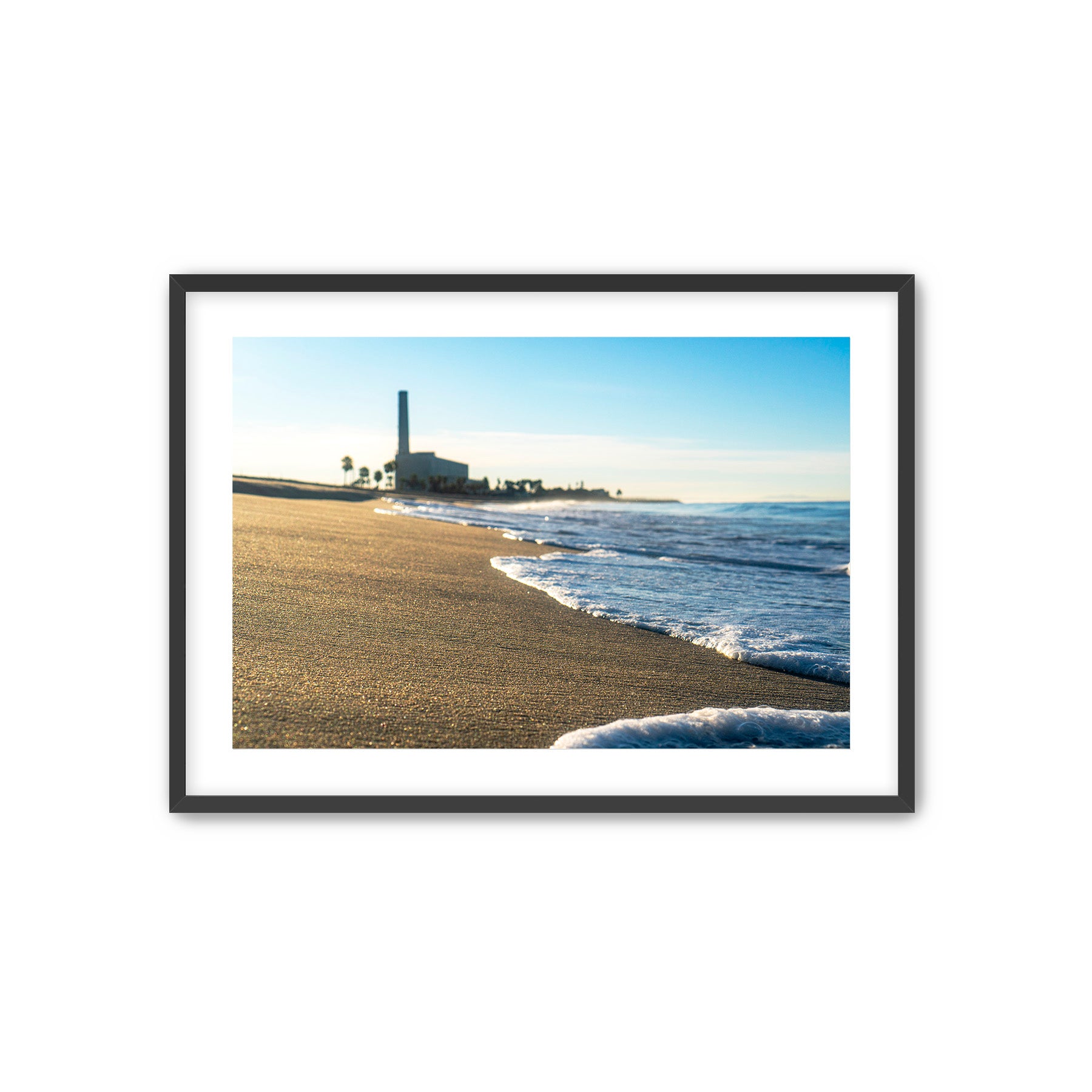Framed photograph of a beach scene with waves and a distant power plant. Carlsbad, California. 