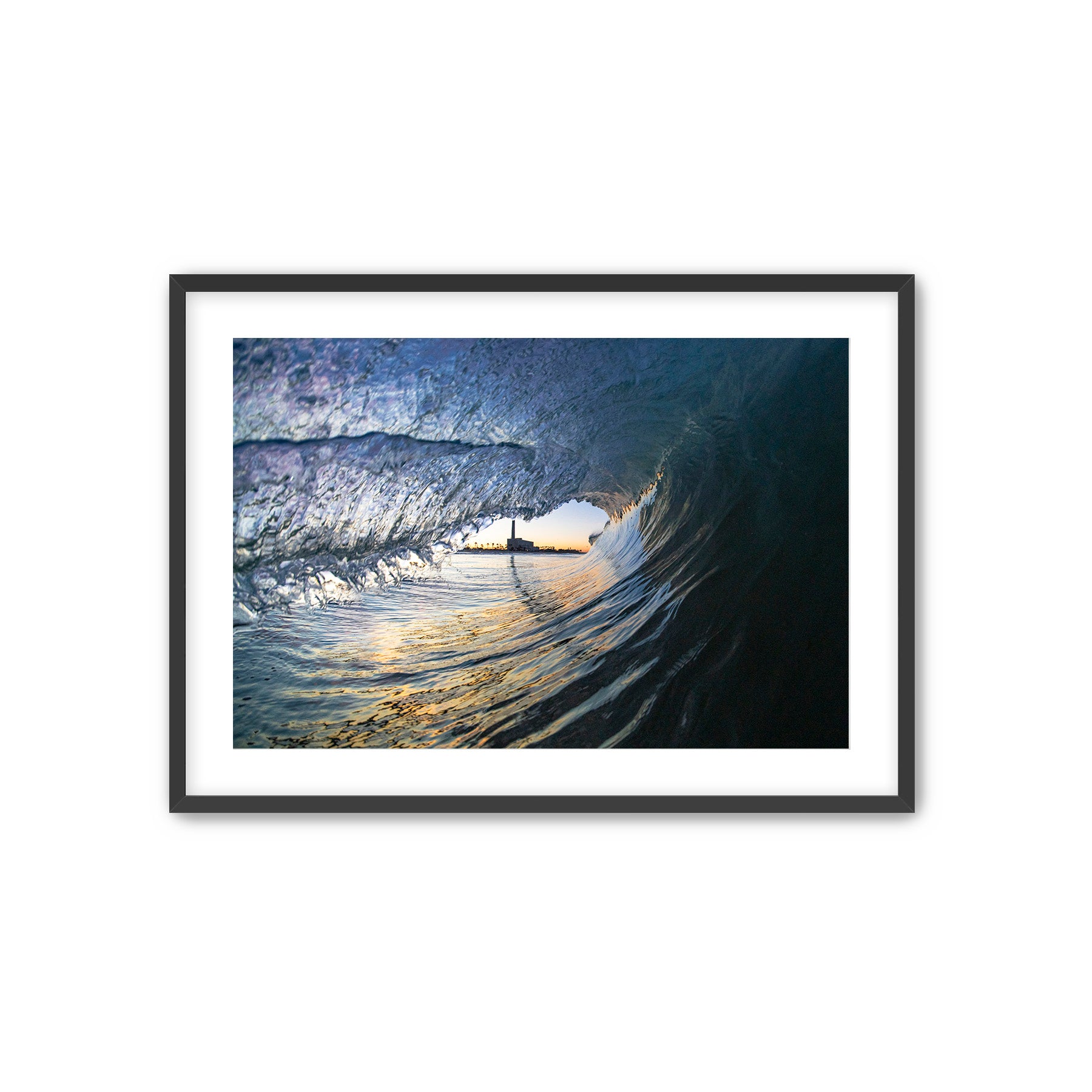 Framed photograph of a barreling wave with the Carlsbad smoke stack in the distance. 