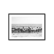 Framed black and white photograph of people surfing in the water at Tamarack beach.