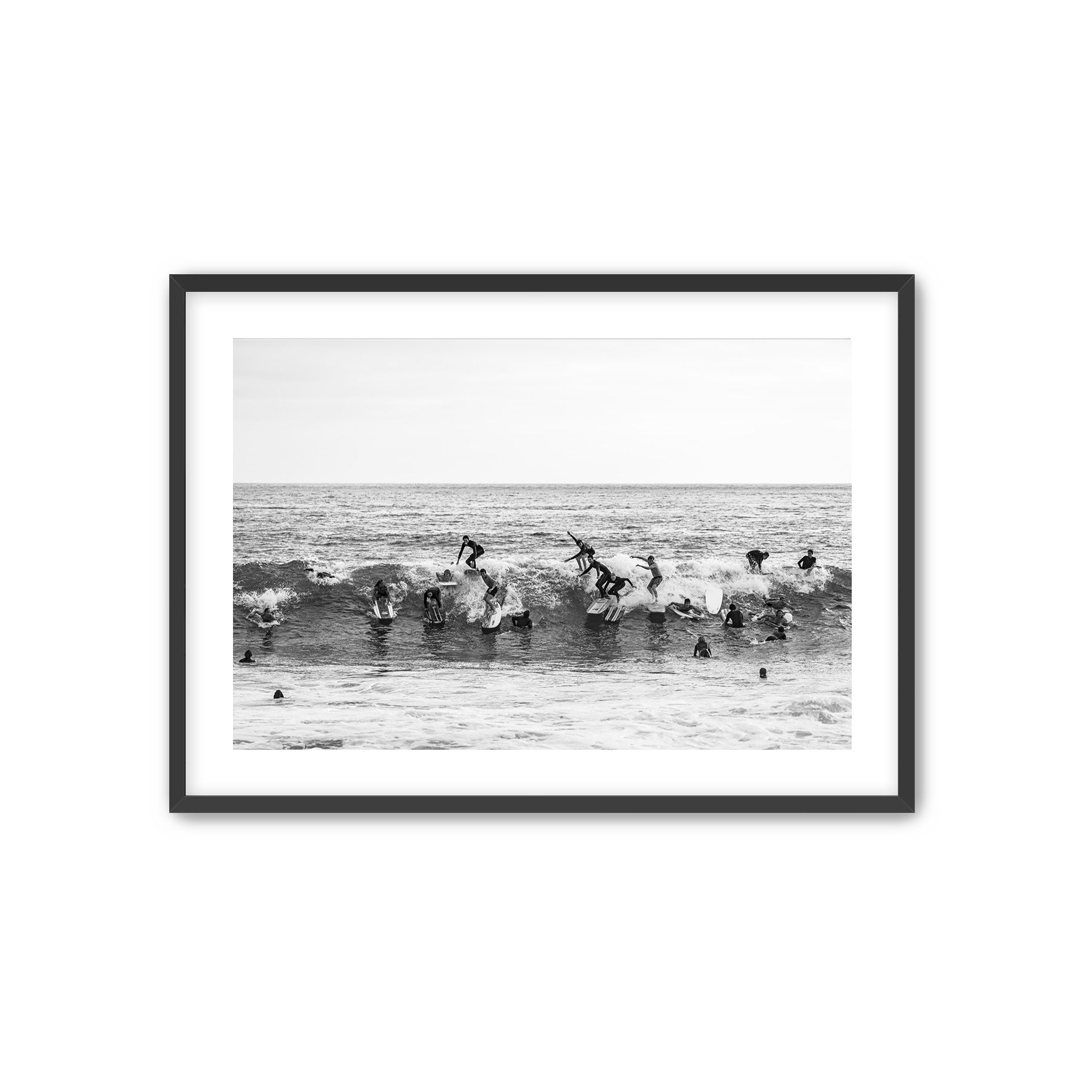 Framed black and white photograph of people surfing in the water at Tamarack beach.