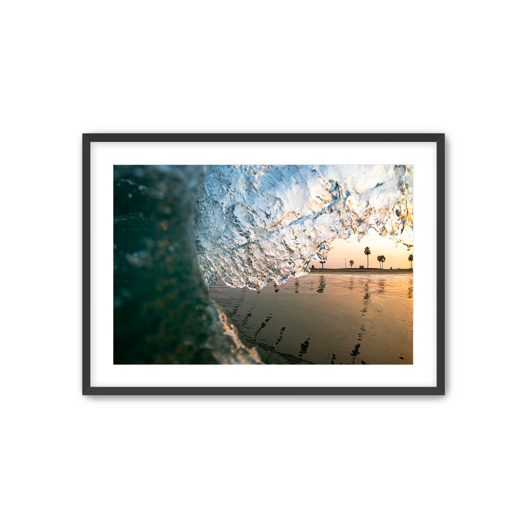 Framed artwork of a photo of palm trees reflected on the surface of the ocean. 