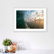 Framed photograph of a beach scene complete with palm tree reflections, placed on a white surface.