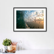 Framed photograph of a beach scene complete with palm tree reflections, placed on a white surface.