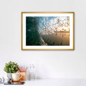 Framed photograph of a beach scene complete with palm tree reflections, placed on a white surface.