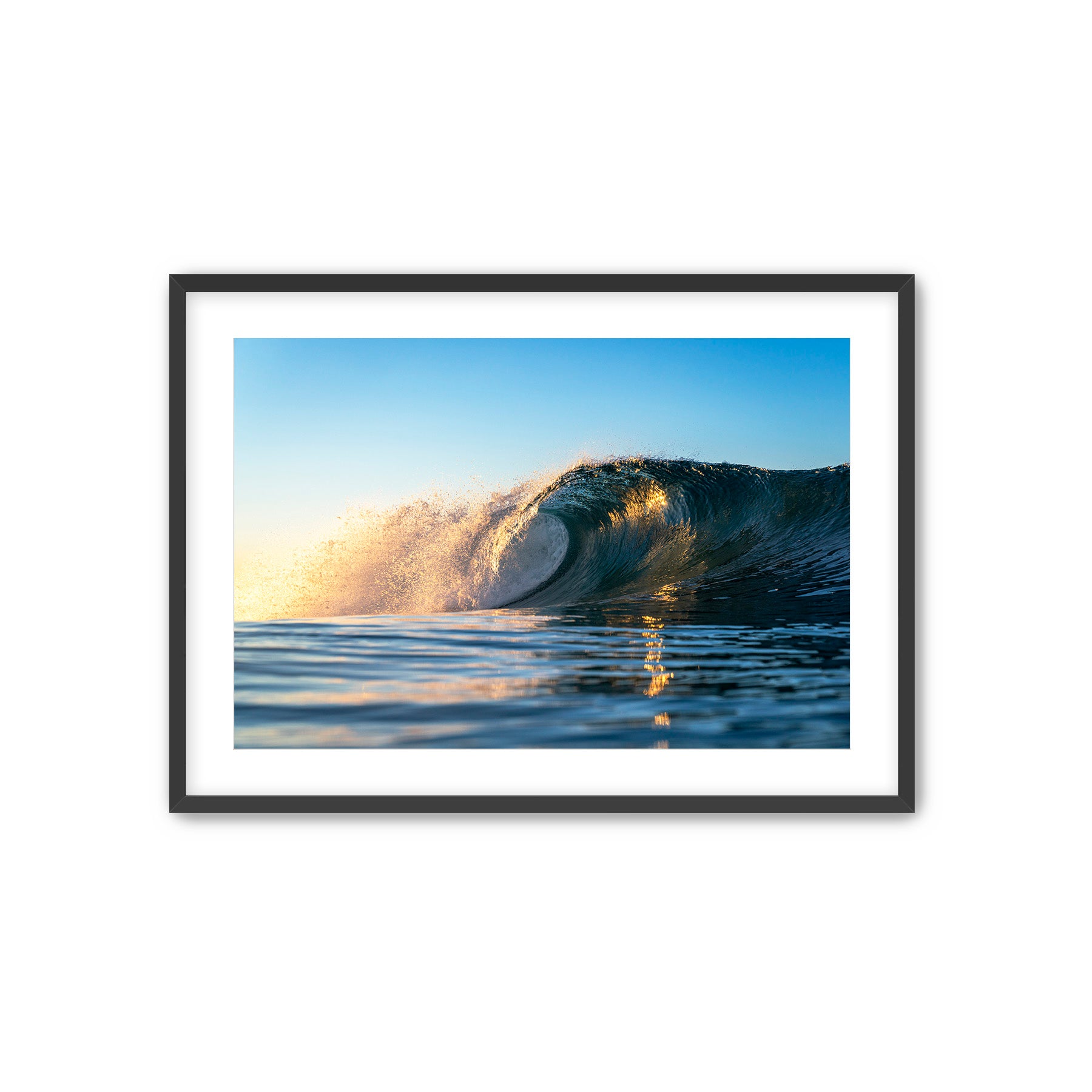 Framed photograph of a wave crashing in the ocean with a black frame.