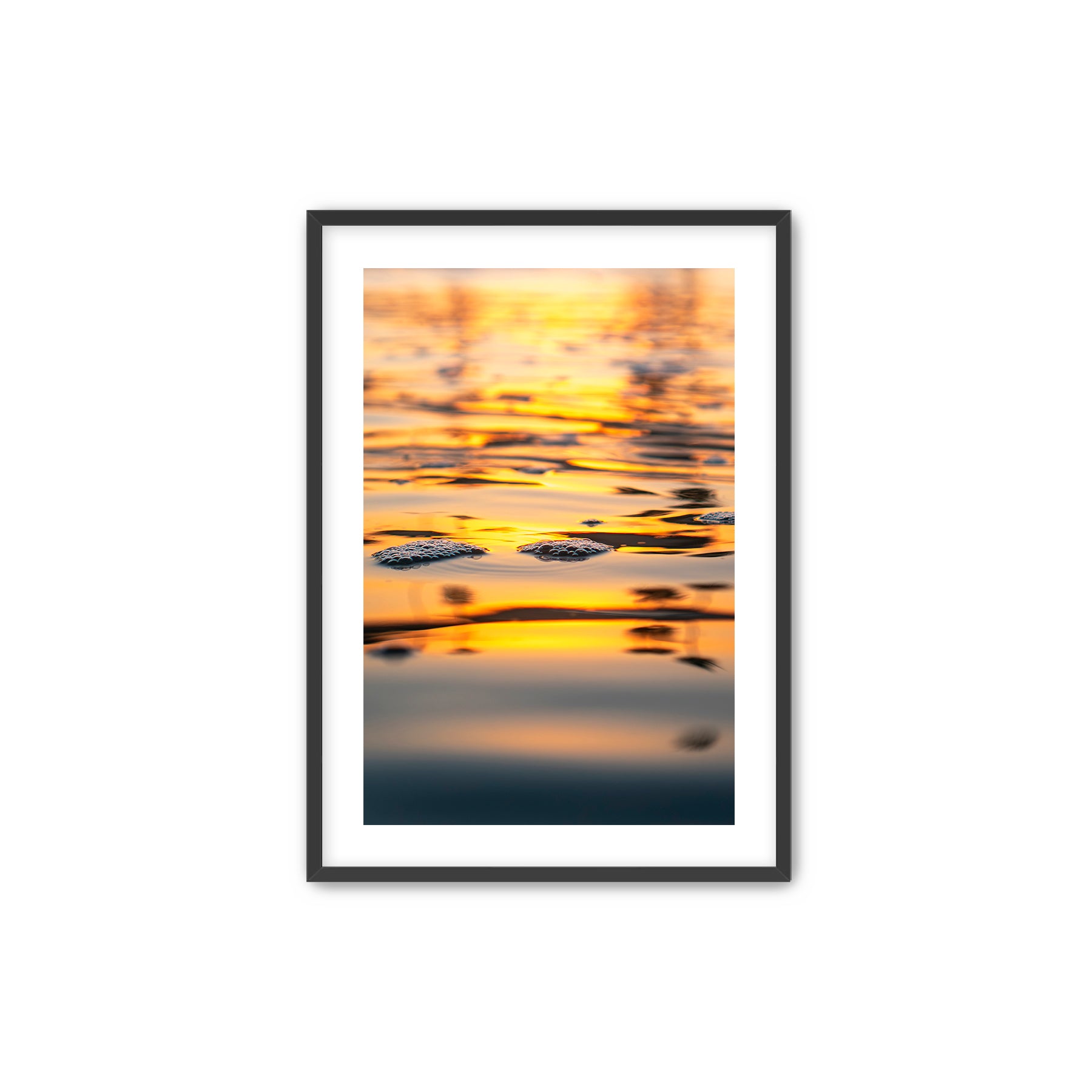 Framed artwork of a sunrise reflection  of palm trees on water.