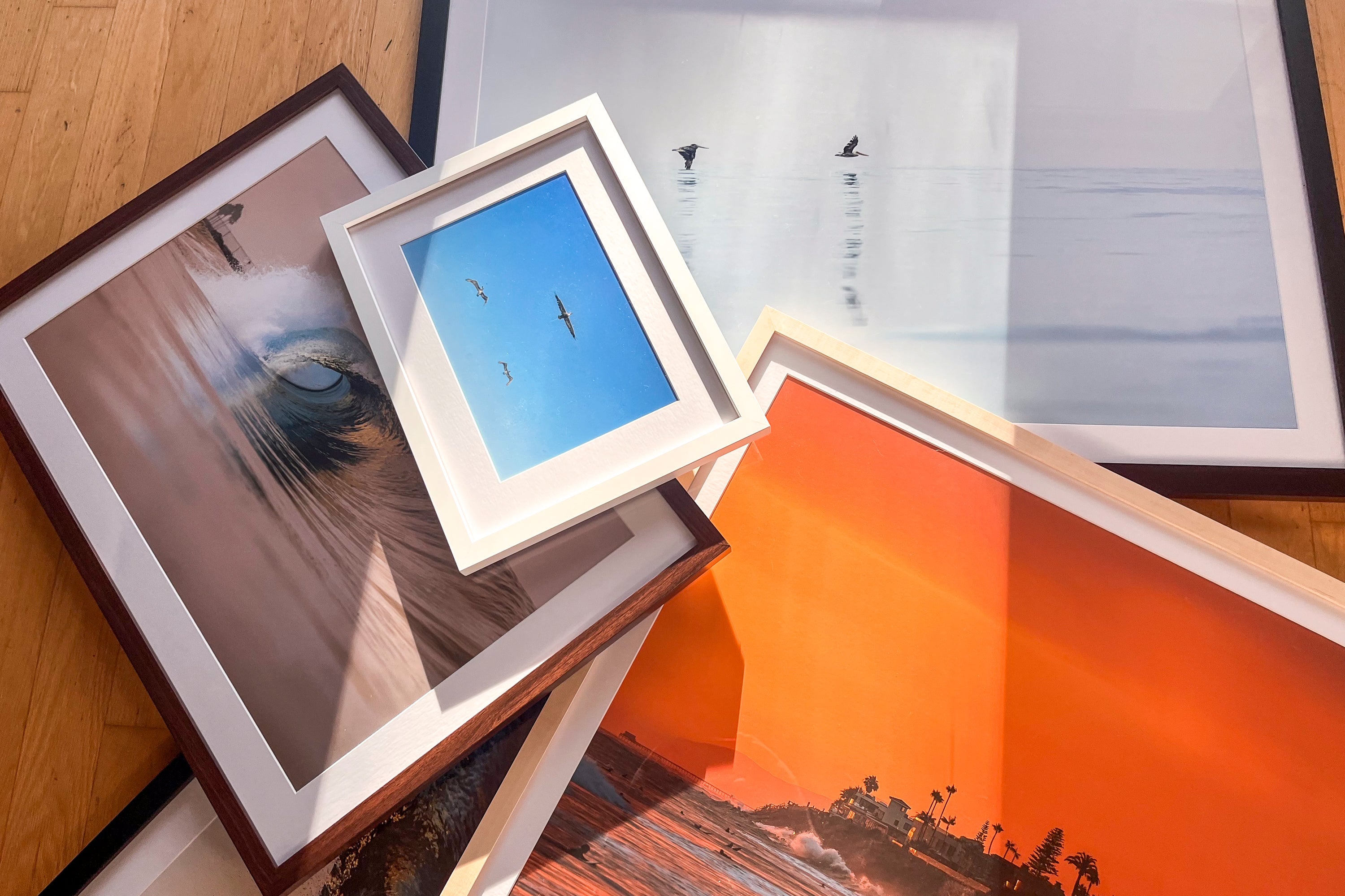 Collection of framed artworks on a wooden surface