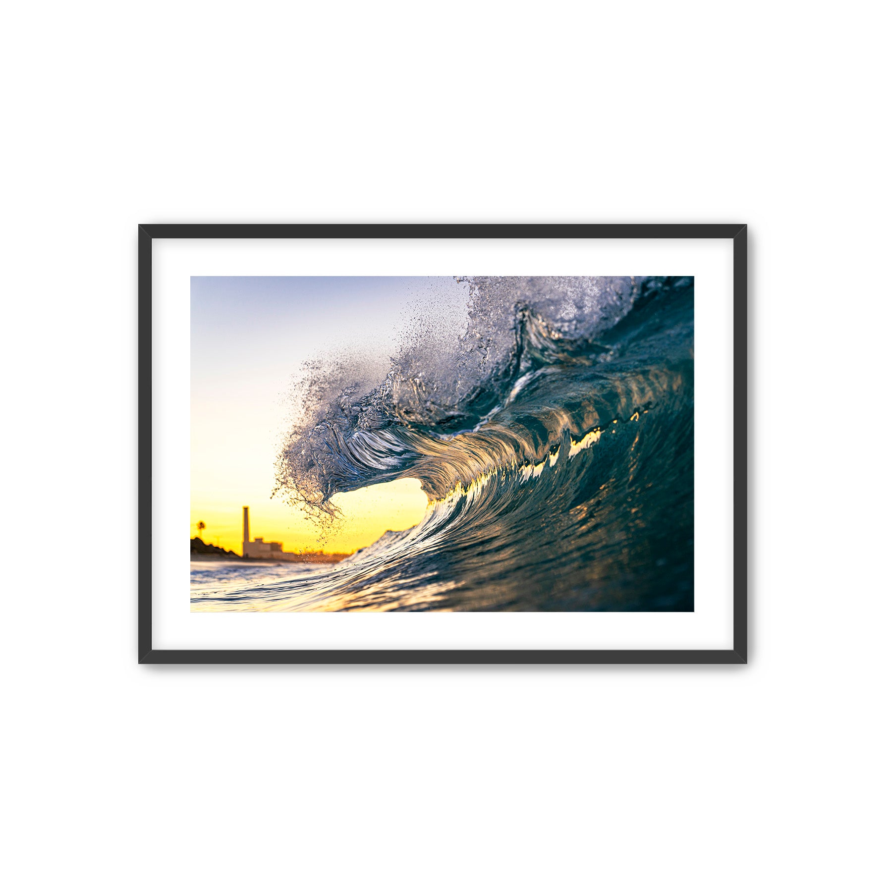Framed photograph of a curling wave at sunset.