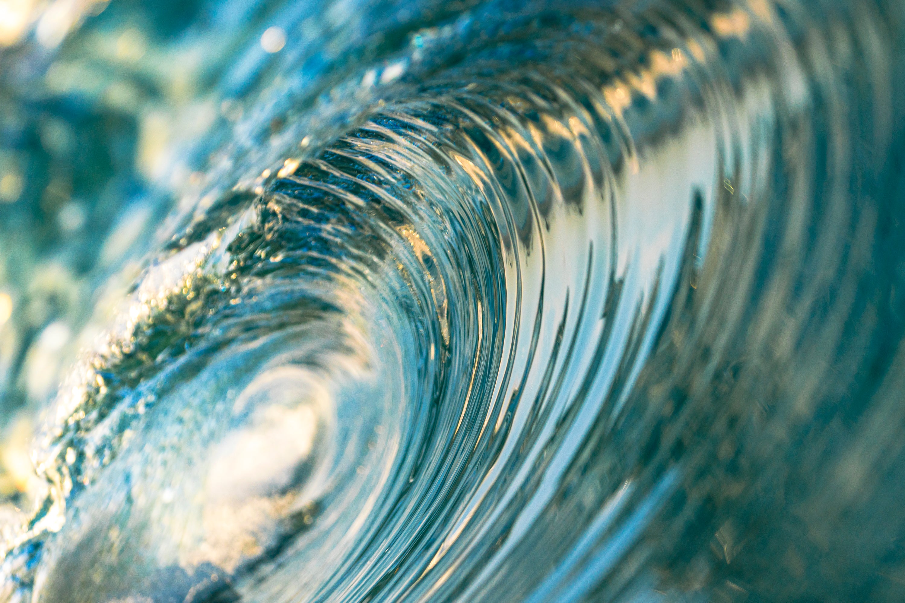 Close-up of a swirling water pattern with light reflections in the barrel of a wave at South Carlsbad State Beach in Carlsbad California. 