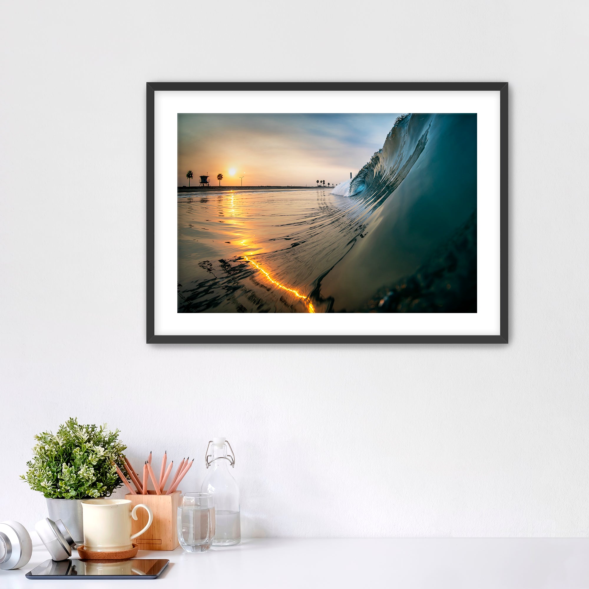 Wave crashing onto a beach with a sunrise reflection on the water. Carlsbad, California. 