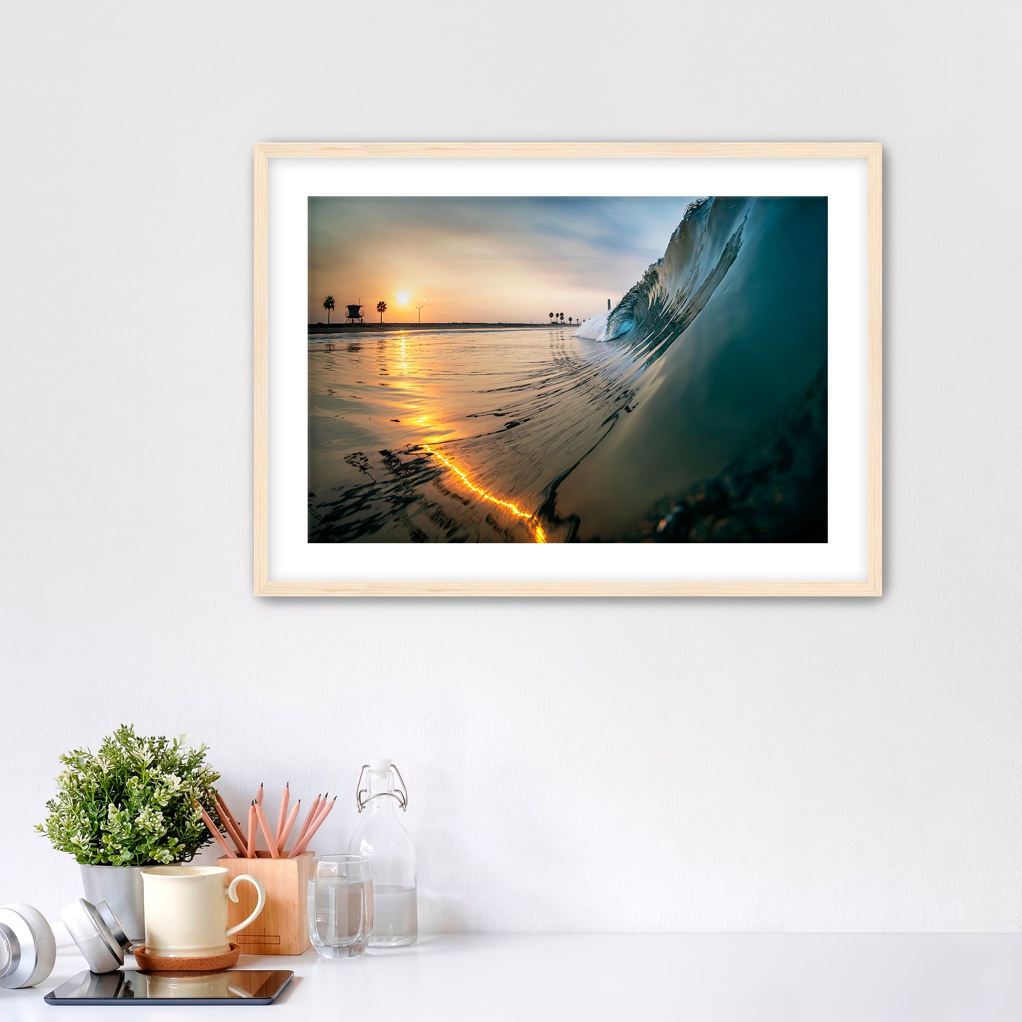 Wave crashing onto a beach with a sunrise reflection on the water. Carlsbad, California. 