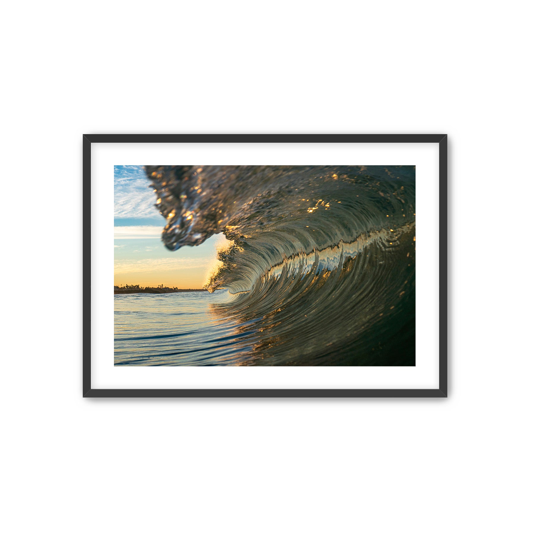 Framed photograph of a tubing wave with a sunrise in the background. 