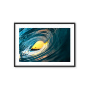 Framed photograph of a swirling wave with a bright center on a white background.